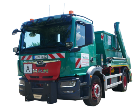 Freigestellter grüner MAN-Absetzkipper des Fuhrbetriebs Hilbert mit aufgenommenem Absetzcontainer, hydraulischer Ladeanlage und auffälliger Warnmarkierung.